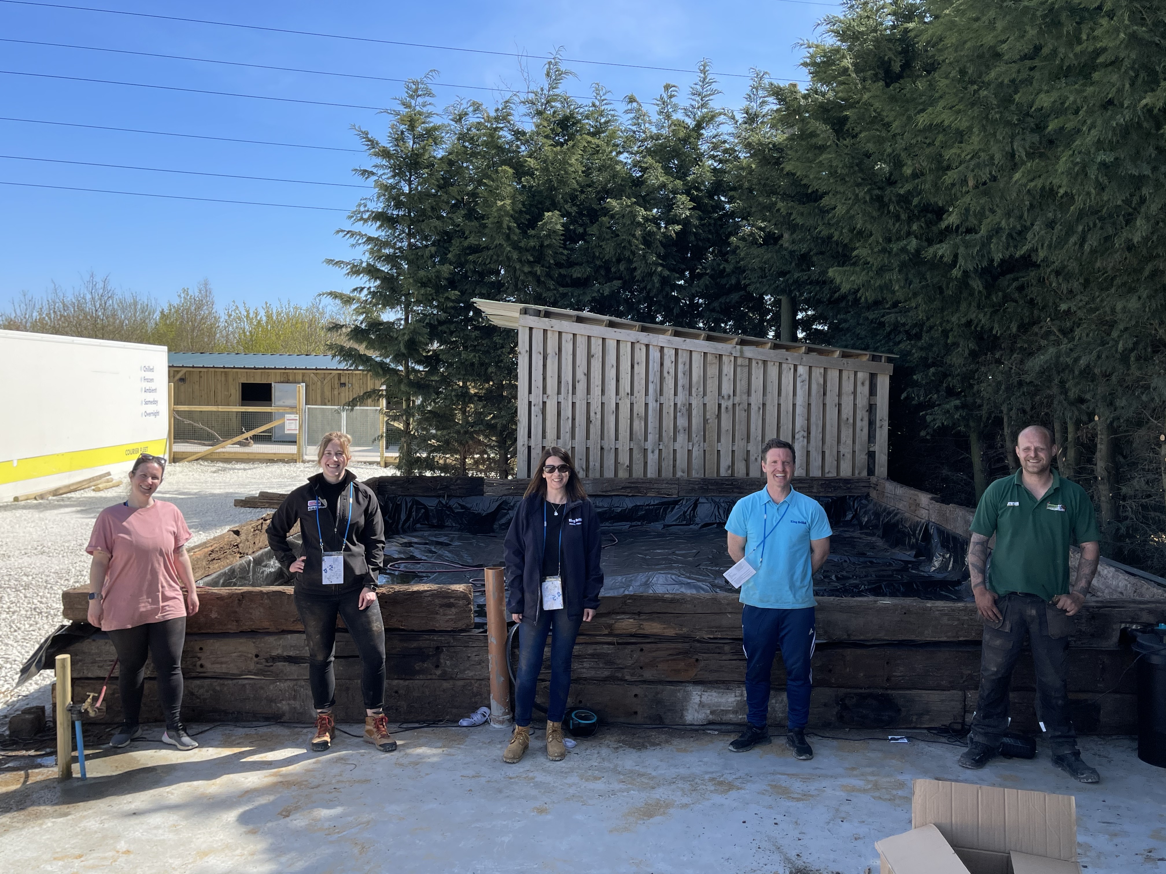 The king british team and andy nts in front of the finished turtle pond